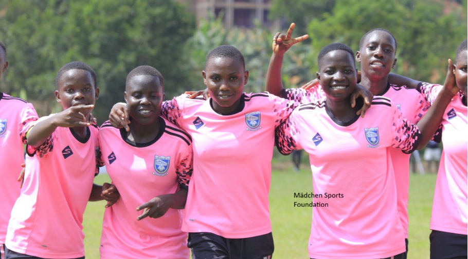 Girls football team smiling together in pink kits