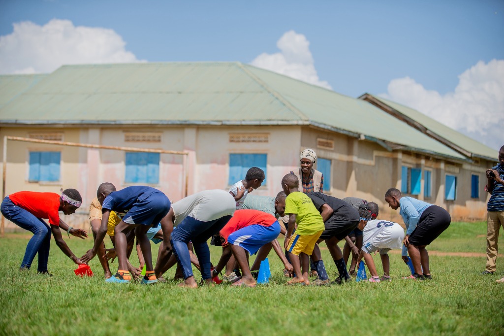 Youth touching cones in a speed and agility training session guided by mentors
